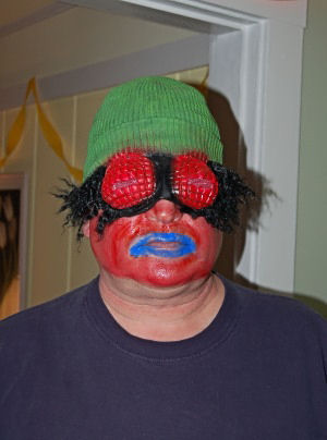 man in fly mask colored red and blue and green