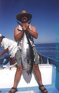 Rick Raives holding up a tuna he just caught