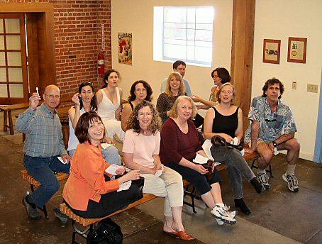 Group of people sitting on benches holding spoons at a lecture