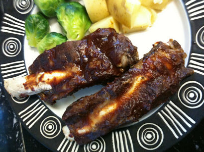 beef ribs displayed on a plate, glistening with sauce