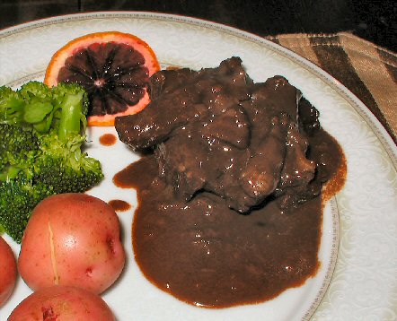 dinner plate with blood orange slice, broccolli,  new red potatoes and chocolate spare ribs